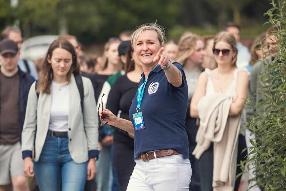 Frau zeigt Studierenden den Weg