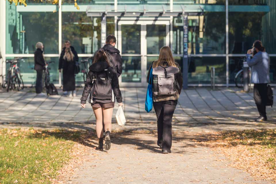 Studentinnen gehen zum Hochschulgebäude